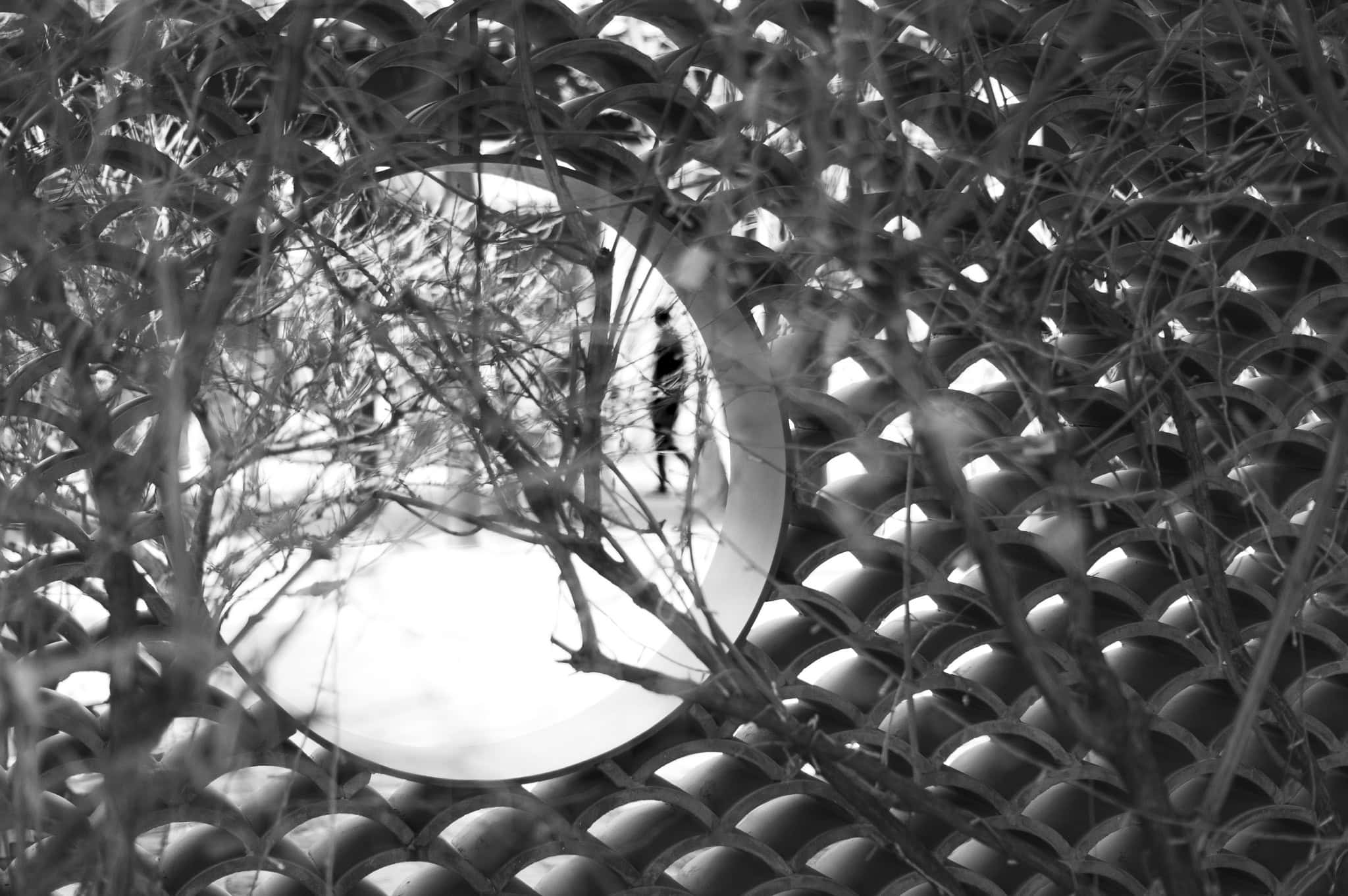 fence-with-peephole-focused-on-blurry-man