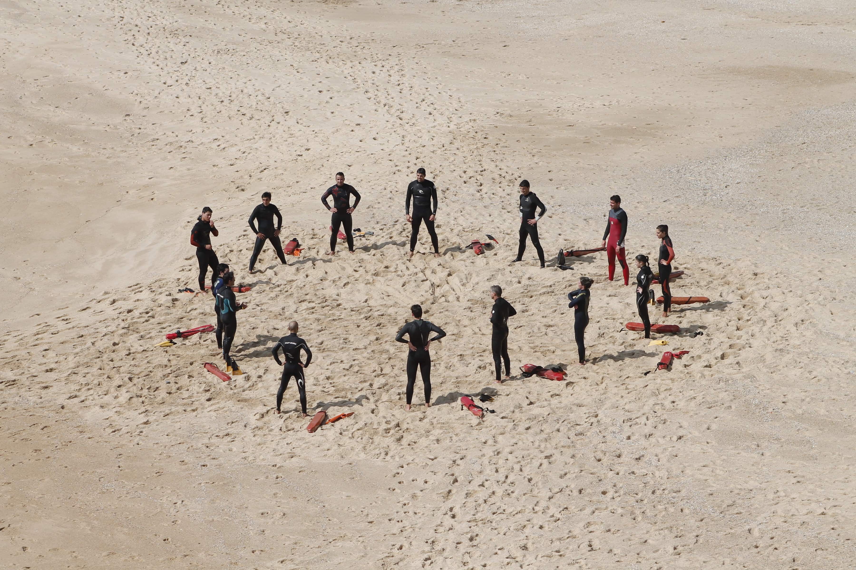 Lifeguards-in-wetsuits-learning-on-the-beach
