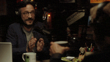 old-man-with-headphones-applauding-in-coffee-shop
